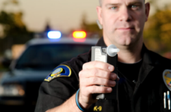 Police officier holding a breathalyzer gun